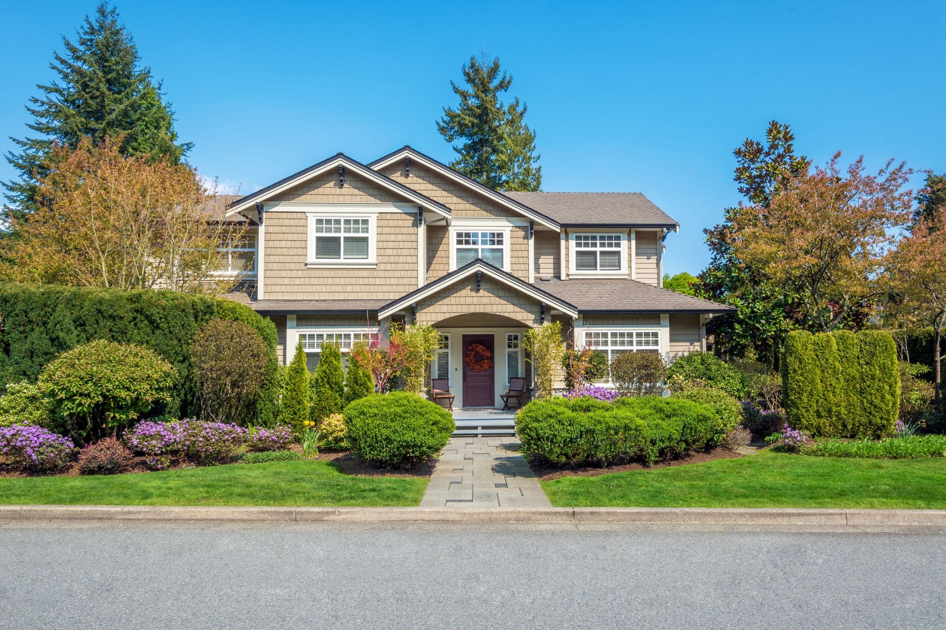 Luxury house with nicely trimmed front yard lawn in a residential neighborhood. Home exterior.